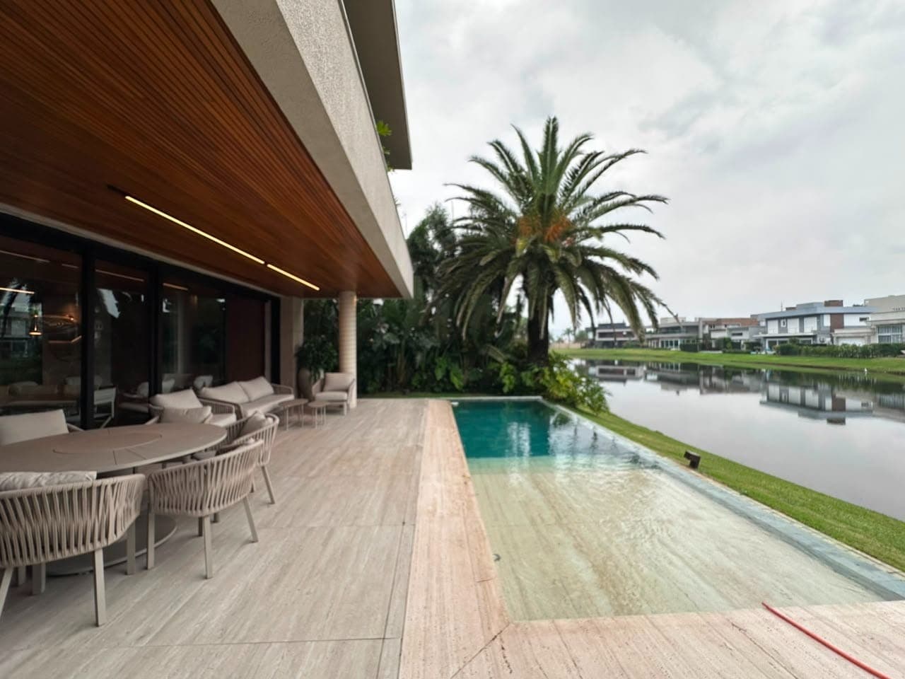 Deck de casa em condomínio de Xangri-Lá com piscina voltada para a laguna
