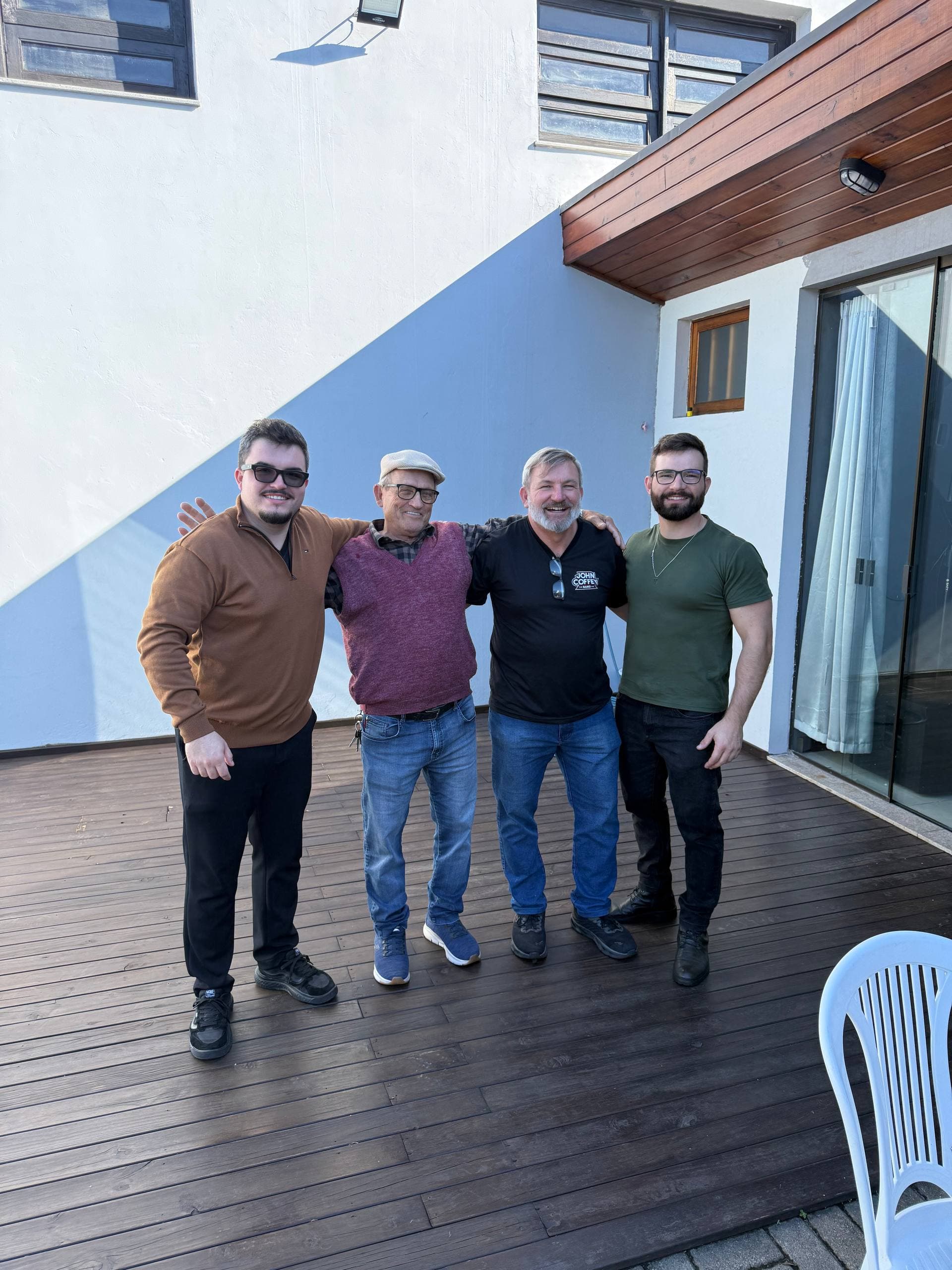 Meu avô, meu pai, meu irmão e eu, lado a lado, abraçados